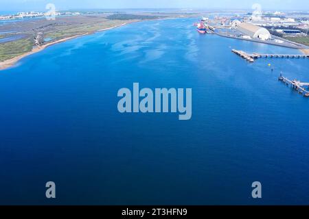 Sorvolando il fiume Odiel attraverso il porto esterno della zona industriale di Huelva per il carico e lo scarico delle navi Foto Stock