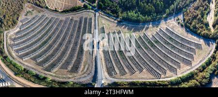 Vista aerea panoramica con droni di una fattoria di pannelli solari tra i campi coltivati Foto Stock