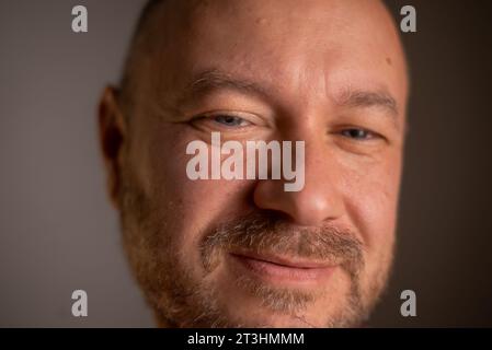 Primo piano di un uomo di 40 anni, incasinato, con un'espressione piacevole e un look quotidiano Foto Stock