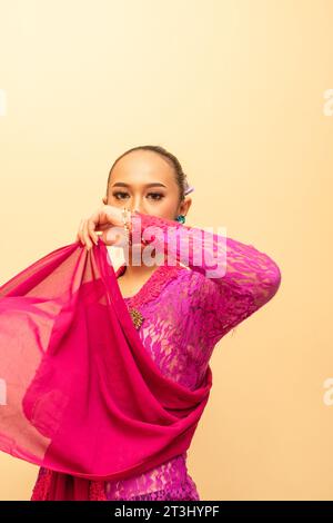 Donna giavanese che indossa un tradizionale abito rosa chiamato kebaya nel giorno dell'indipendenza indonesiana Foto Stock