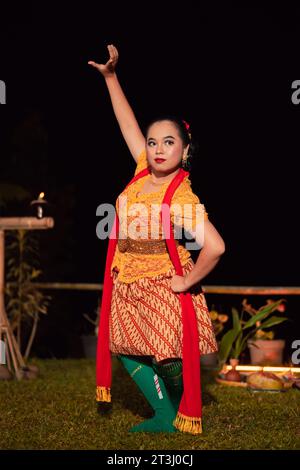 Le donne indonesiane indossano costumi di danza tradizionali chiamati kebaya e posano con movimenti di danza la sera dopo lo spettacolo Foto Stock