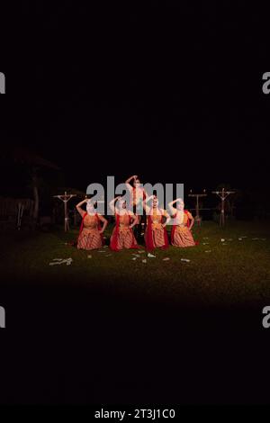 I ballerini asiatici si mettono in posa con movimenti di danza mentre eseguono la danza tradizionale durante la competizione durante la notte Foto Stock