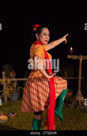 Donna asiatica che esegue una danza tradizionale chiamata jaipong in Indonesia con un vestito giallo e una sciarpa rossa al festival di danza Foto Stock