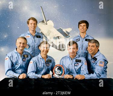 Equipaggio STS-9. Seduti da sinistra a destra sono Owen Garriott, specialista di missione; Brewster Shaw, pilota; John Young, comandante; e Robert Parker, Specialista di missione. Da sinistra a destra ci sono Byron Lichtenberg e Ulf Merbold, specialisti del carico utile. STS-9 è stata la seconda missione operativa dello Space Shuttle Columbia. Foto Stock