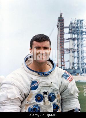 Fred Haise, l'astronauta Fred W. Haise Jr., pilota modulo lunare della missione di atterraggio lunare Apollo 13 con razzo Saturn V dietro. Foto Stock