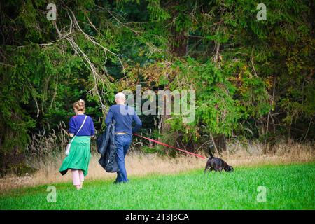 23.10.2023, Mattsee, AUT, Unterwegs in der SALZBURG, Themenbild, Verschiedene Themenbilder, Symbolbild, Herbst 2023, Herbst rund um den Mattsee, im Bild Ein Pärchen geht mit einem Hund Spazieren, Hund, Spazieren, Paar, Frau, Mann, *** 23 10 2023, Mattsee, AUT, On the Way in the SALZBURG, immagine tema, varie immagini tema, immagine simbolo, autunno 2023, autunno intorno a Mattsee, nell'immagine Una coppia sta camminando con un cane, un cane, una passeggiata, una coppia, una donna, uomo, Foto Stock