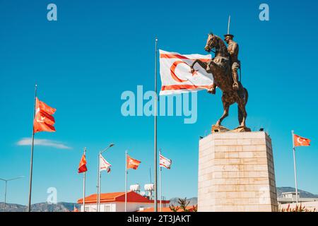 Le bandiere di Türkiye e Cipro settentrionale volano accanto a una statua di Atatürk a cavallo in una rotatoria a nord di Nicosia Foto Stock