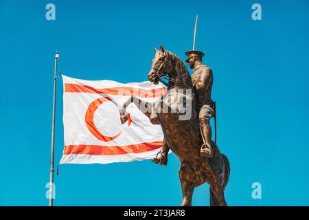 Le bandiere di Türkiye e Cipro settentrionale volano accanto a una statua di Atatürk a cavallo in una rotatoria a nord di Nicosia Foto Stock