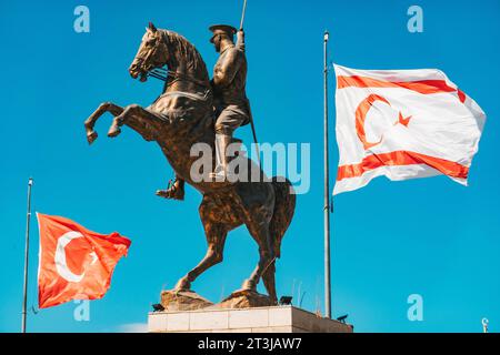 Le bandiere di Türkiye e Cipro settentrionale volano accanto a una statua di Atatürk a cavallo in una rotatoria a nord di Nicosia Foto Stock