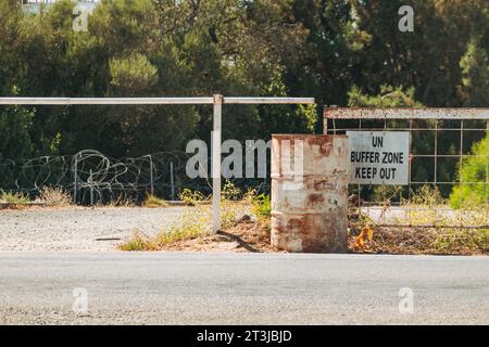 Un cartello recita "zona tampone delle Nazioni Unite, tenersi fuori” in un passaggio di frontiera tra le regioni settentrionali e meridionali dell'isola di Cipro Foto Stock