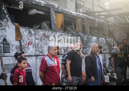 Gaza, Palestina. 25 ottobre 2023. Un autobus danneggiato è visto come i palestinesi cercano i sopravvissuti e i corpi delle vittime attraverso edifici distrutti durante i bombardamenti israeliani, a Khan Yunis nella Striscia di Gaza meridionale il 25 ottobre 2023, in mezzo alle continue battaglie tra Israele e il gruppo palestinese Hamas. Credito: SOPA Images Limited/Alamy Live News Foto Stock