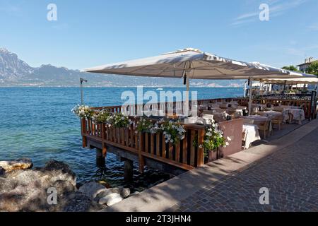 Terrazza ristorante sulla riva del lago, luce del mattino, Torri del Benaco, riva orientale del Lago di Garda, provincia di Verona, Italia Foto Stock