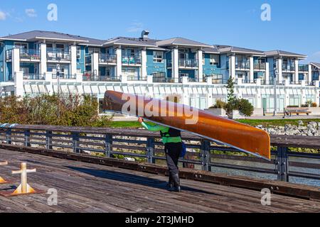 Persona che porta una canoa sul lungomare di Steveston, nella Columbia Britannica, Canada Foto Stock