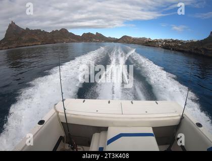 La barca da pesca con mulinelli armati si dirige fuori dalla baia per una mattinata di pesca sportiva. Piccola barca veloce. Foto Stock