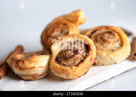 Dolci e croccanti panini alla cannella appena sfornati. Su uno sfondo bianco, primo piano Foto Stock