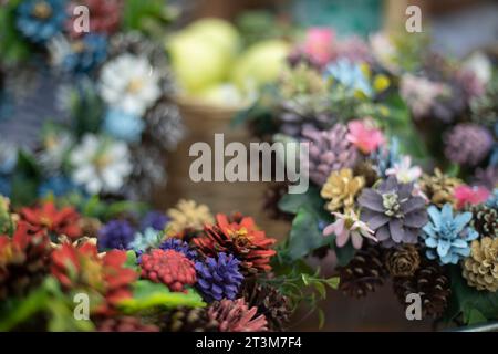 Composizione degli elementi naturali. Consistenza naturale di splendidi fiori. Coni verniciati in colori diversi. Uno sfondo di piante. Foto Stock