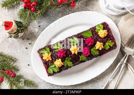 Insalata shuba a strati per le feste. Involtino tradizionale di insalata di verdure di Natale russo con aringhe e verdure bollite. Vista dall'alto. Foto Stock