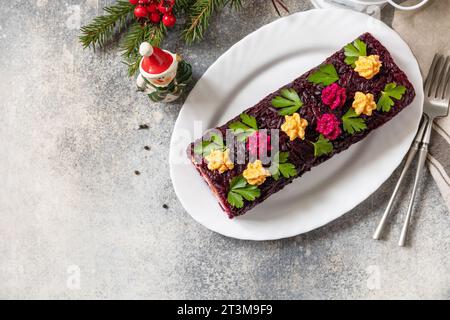 Insalata shuba a strati per le feste. Involtino tradizionale di insalata di verdure di Natale russo con aringhe e verdure bollite. Vista dall'alto. Copia spa Foto Stock