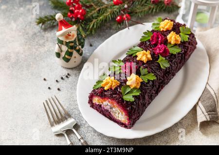 Insalata shuba a strati per le feste. Involtino tradizionale di insalata di verdure di Natale russo con aringhe e verdure bollite. Copia spazio. Foto Stock