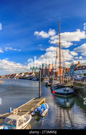 Un mix di barche per il tempo libero e da pesca ormeggiate lungo il Quay con il suo Granary a 5 piani a Wells-Next-the-Sea, Norfolk, Inghilterra, Regno Unito Foto Stock