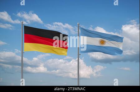 Argentina e Germania bandiere che sventolano insieme su un cielo nuvoloso blu, concetto di relazione tra due paesi Foto Stock