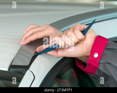 utilizzo dell'attrezzo di smontaggio per la carrozzeria di un'auto Foto Stock