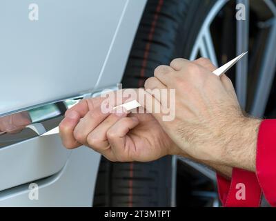 utilizzo dell'attrezzo di smontaggio per la carrozzeria di un'auto Foto Stock