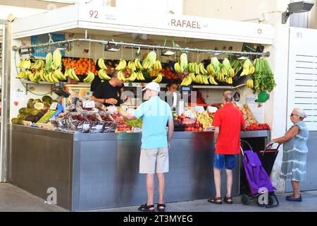 I clienti aspettano di essere serviti presso la bancarella di prodotti freschi a Cadice, Spagna, il 3 agosto 2023 Foto Stock