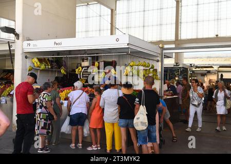 I clienti aspettano di essere serviti presso la bancarella di prodotti freschi a Cadice, Spagna, il 3 agosto 2023 Foto Stock