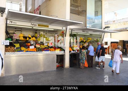 I clienti aspettano di essere serviti presso la bancarella di prodotti freschi a Cadice, Spagna, il 3 agosto 2023 Foto Stock