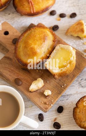 Pasticciotto leccese ripieno di crema pasticcera all'uovo, dolce tipico di Lecce, Italia. Pezzi di pasticiotto su tavola di legno, colazione pugliese Foto Stock