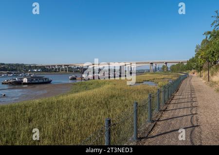 Sentiero lungo il fiume che conduce ai ponti Medway sul fiume Medway, Rochester, Kent, Regno Unito. Foto Stock