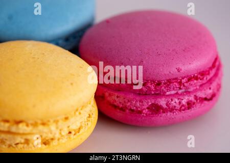 macaron di colori diversi e vari cioccolatini su sfondo bianco in primo piano Foto Stock