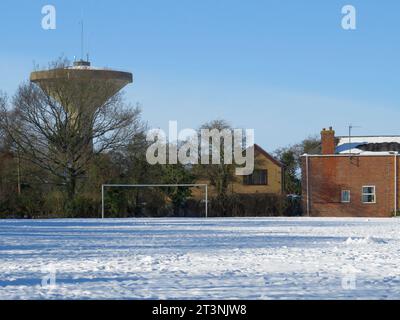 La torre d'acqua nel quartiere Skirbeck, vista dal campo da gioco innevato durante il freddo inverno del 2021 Foto Stock