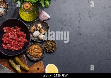 Cottura di una saporita tartare di manzo con cetriolini sottaceto e pane tostato. Base piatta con spazio per la copia Foto Stock
