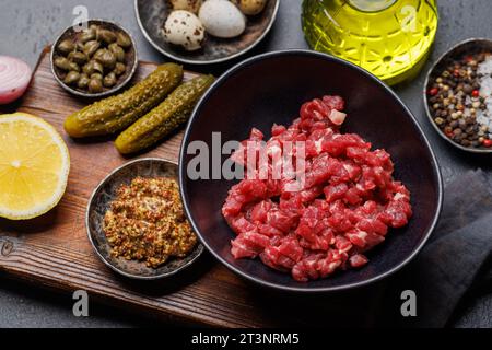 Cottura di una saporita tartare di manzo con cetriolini sottaceto e pane tostato Foto Stock