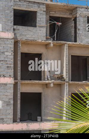 Santa Maria, Isola di Sal - Capo Verde, 02 ottobre 2023: Costruzione di un edificio incompiuto con un uomo in abito bianco Foto Stock