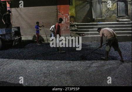 Kathmandu, Bagmati, Nepal. 26 ottobre 2023. I lavoratori migranti indiani diffusero asfalto caldo mentre si stava facendo un blacktopping Road a Kathmandu, Nepal, il 26 ottobre 2023. (Immagine di credito: © Sunil Sharma/ZUMA Press Wire) SOLO USO EDITORIALE! Non per USO commerciale! Foto Stock