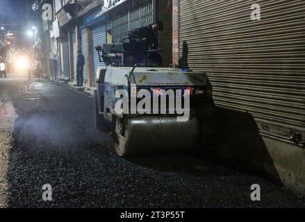 Kathmandu, Bagmati, Nepal. 26 ottobre 2023. Un lavoratore migrante indiano gestisce roller mentre sta facendo blacktopping Road a Kathmandu, Nepal, il 26 ottobre 2023. (Immagine di credito: © Sunil Sharma/ZUMA Press Wire) SOLO USO EDITORIALE! Non per USO commerciale! Foto Stock