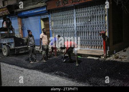 Kathmandu, Bagmati, Nepal. 26 ottobre 2023. I lavoratori migranti indiani diffusero l'asfalto mentre si stava abbattendo la strada a Kathmandu, Nepal, il 26 ottobre 2023. (Immagine di credito: © Sunil Sharma/ZUMA Press Wire) SOLO USO EDITORIALE! Non per USO commerciale! Foto Stock