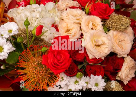 Bouquet autunnale di rose rosse e bianche, ortensie, crisantemi come sfondo. Vista dall'alto. Foto Stock