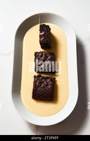 Brownie con latte condensato. I brownie sono composti da latte condensato, cacao e burro. Con gocce di cioccolato. Foto Stock
