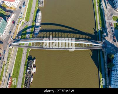 Cracovia, Polonia. Doppio ponte sospeso sotto un arco: Passerella pedonale e ponte in bicicletta sul fiume Vistola, chiamato kladka Bernatka. Popolare e turistico Foto Stock