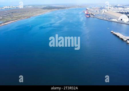 Sorvolando il fiume Odiel attraverso il porto esterno della zona industriale di Huelva per il carico e lo scarico delle navi Foto Stock