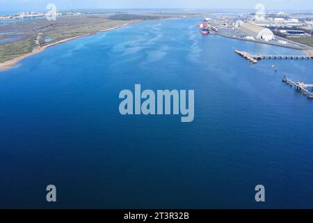 Sorvolando il fiume Odiel attraverso il porto esterno della zona industriale di Huelva per il carico e lo scarico delle navi Foto Stock