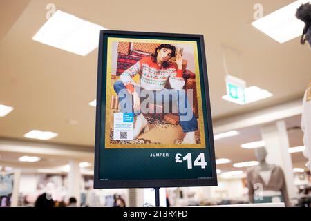 Maglione natalizio Primark nel poster pubblicitario del punto vendita con modello dall'aspetto androgino in posa maschile Foto Stock