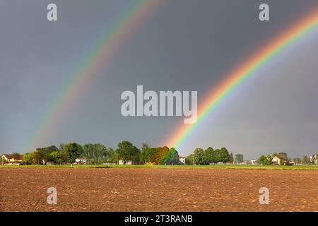 Vista di un doppio arcobaleno su uno splendido paesaggio collinare a Reggio Emilia, Italia. Foto Stock
