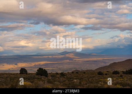 Pittoresca alba nuvolosa nella Valle di Owens. Illuminazione dorata e piante durante l'autunno nei Buttermilks ai piedi delle montagne della Sierra Nevada. Foto Stock