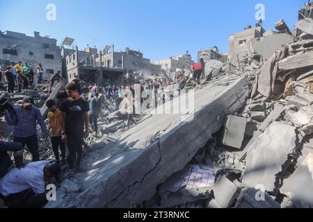 I palestinesi cercano i sopravvissuti e i corpi delle vittime attraverso le macerie di edifici distrutti durante i bombardamenti israeliani, a Khan Yunis nella Striscia di Gaza meridionale il 26 ottobre 2023, in mezzo alle continue battaglie tra Israele e il gruppo palestinese Hamas. Migliaia di civili, sia palestinesi che israeliani, sono morti dal 7 ottobre 2023, dopo che i militanti palestinesi di Hamas con base nella Striscia di Gaza sono entrati nel sud di Israele in un attacco senza precedenti che ha innescato una guerra dichiarata da Israele ad Hamas con attentati di rappresaglia a Gaza. Credito: SOPA Images Limited/Alamy Live News Foto Stock