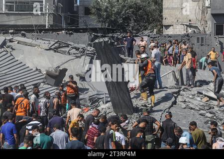 I palestinesi cercano i sopravvissuti e i corpi delle vittime attraverso le macerie di edifici distrutti durante i bombardamenti israeliani, a Khan Yunis, nella Striscia di Gaza meridionale, in mezzo alle continue battaglie tra Israele e il gruppo palestinese Hamas. Migliaia di civili, sia palestinesi che israeliani, sono morti dal 7 ottobre 2023, dopo che i militanti palestinesi di Hamas con base nella Striscia di Gaza sono entrati nel sud di Israele in un attacco senza precedenti che ha innescato una guerra dichiarata da Israele ad Hamas con attentati di rappresaglia a Gaza. (Foto di Ahmed Zakot/SOPA Images/Sipa USA) Foto Stock